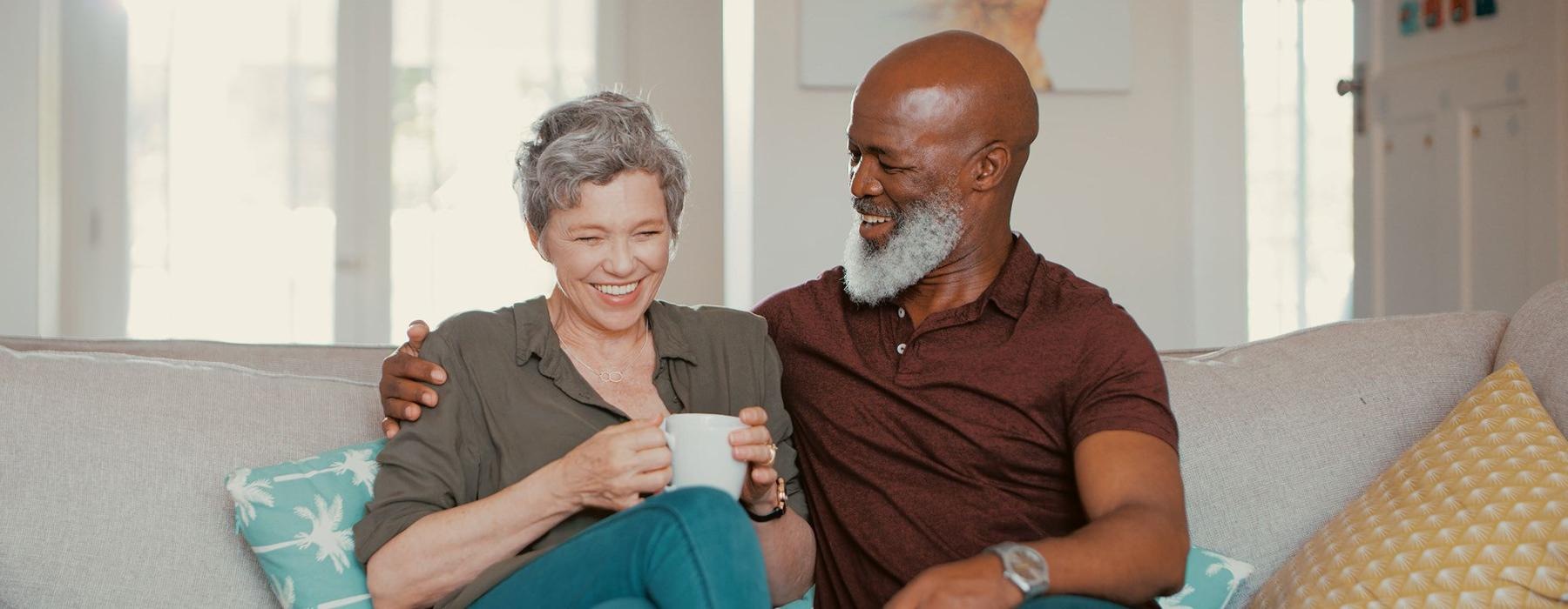 smiling, older couple, sit together on a couch